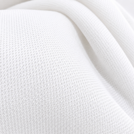 polyester Nirmal knit fabric
white polyester knit fabric
breathable activewear fabric
polyester T-shirt fabric
wholesale knit fabric
bulk apparel fabric supplier
Close-up of white Polyester Nirmal Knit fabric with a fine knitted texture arranged in soft folds.