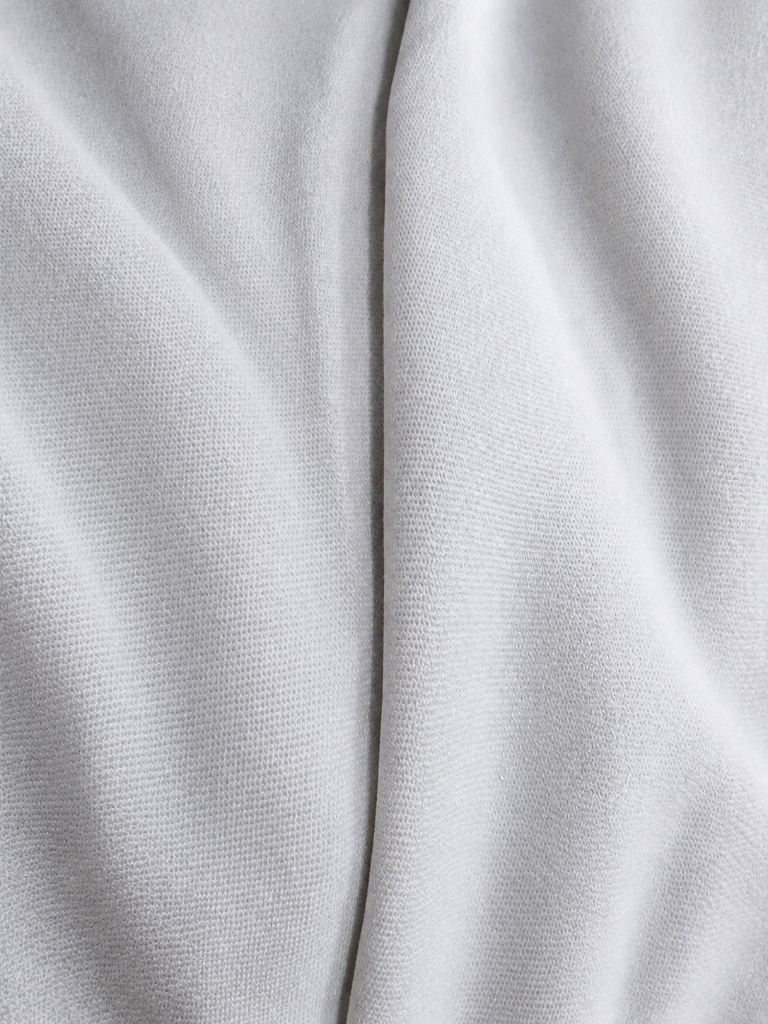 Adidas Saleena white knit fabric spiral view showing soft texture and premium polyester sportswear fabric quality